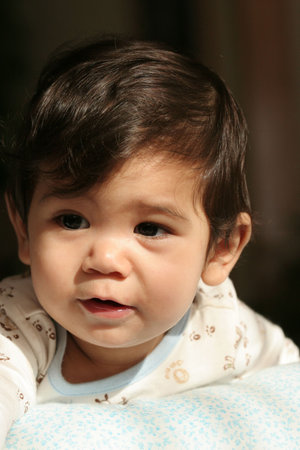 Handsome baby boy playing on his stomach, part asian background.