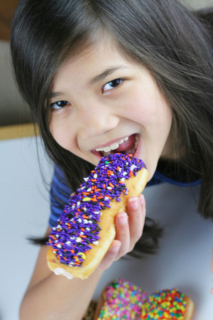 Girl eating colorful filled donut