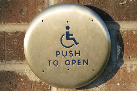 Handicap push to open button along exterior brick wallの写真素材