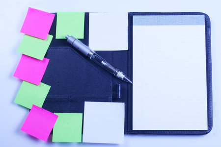 Planner opened, with blank notepad, sticky notes and pen.