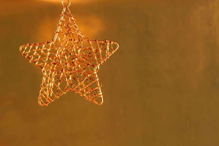 Gold star ornament on gold shiny background.の写真素材