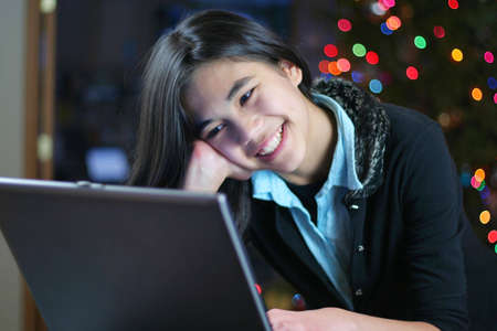 Young teen girl working on the laptop at night.の写真素材