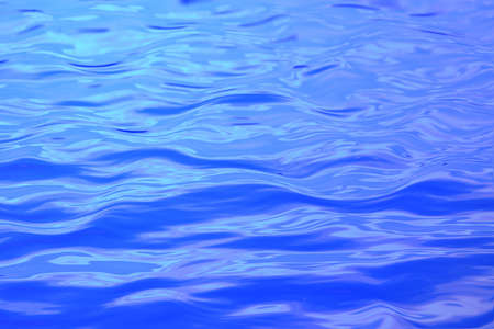 Soft blue waves in calm watersの写真素材