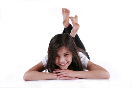 Beautiful ten year old girl happily relaxing on floorの写真素材