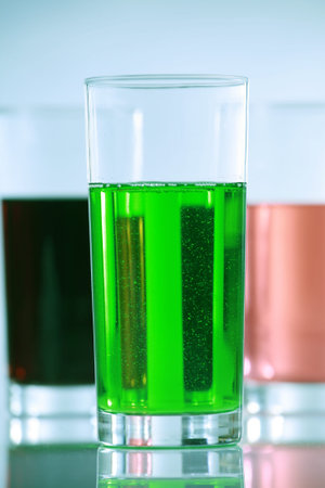 Three glasses with colorful drinks, side by side. blue tones in backgroundの写真素材