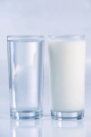 Glass of water and milk, side by side, with blue tones,. Shallow DOFの写真素材