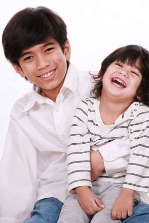 Two brothers laughing together, both are of part Asian - Scandinavian descentの写真素材