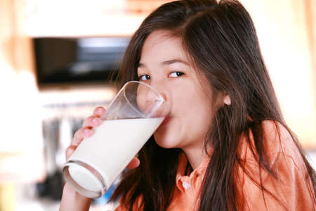 Girl drinking milk in kitchenの写真素材