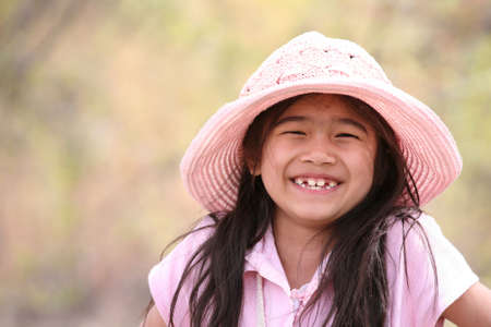 Adorable girl in pink smiling outdoorsの写真素材