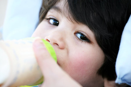 Baby boy drinking milk from bottle