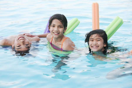 Children having fun in swimming poolの写真素材