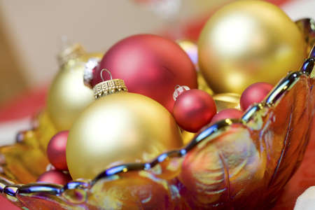 Red and gold ornaments in bowlの写真素材