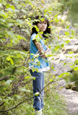 Girl lost in woods, scared, looking around in surpriseの写真素材