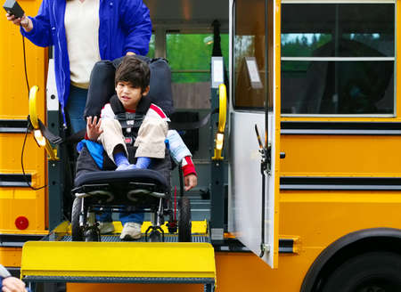 Disabled five year old boy using a bus lift for his wheelchairの写真素材