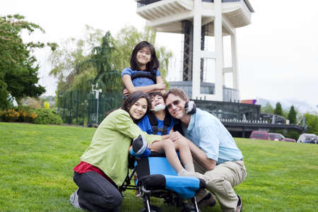 Disabled boy in wheelchair surrounded by family, outdoors by the Space Needle in Seattleの写真素材