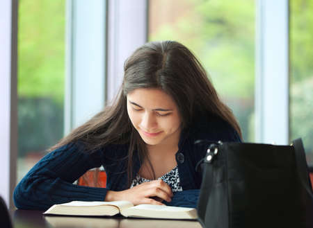 College student studying at school, reading bookの写真素材
