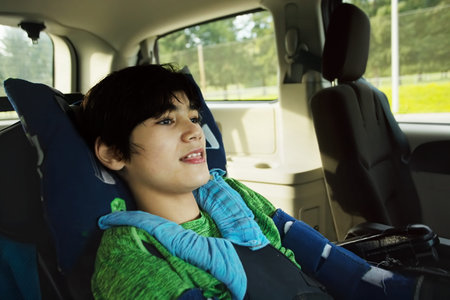 Smiling twelve year old biracial disabled boy in handicap vehicle sitting in wheelchair