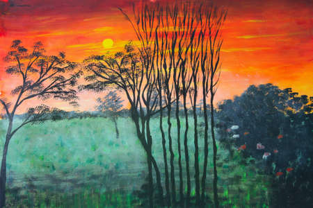Beautiful red and orange sunrise over a misty field at dawnの写真素材
