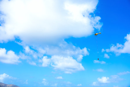 Rescue helicopter carrying water from ocean to fire siteの写真素材
