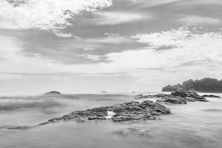 Waves crashing on a rock in the beachの写真素材