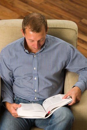 Man reading book on the armchair.の写真素材
