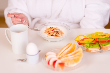 Woman eating breakfat on the morning table.の写真素材