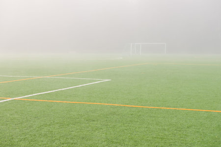 Empty soccer field early in the foggy morning 