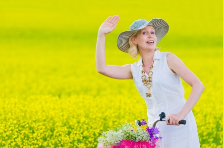 Woman waving hand, rapeseed on backgroundの写真素材