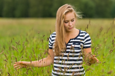 Young beauty girl walking on the meadow and focus on the faceの写真素材