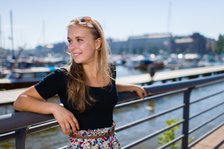 Young beautiful girl rests near the harbour, sunny dayの写真素材