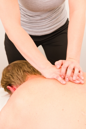 Professional masseur doing massage of male backの写真素材