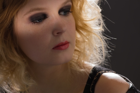 Portrait of pretty girl on dark background, back-light, horizon formatの写真素材