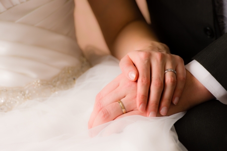 Closeup of a bride and groom holding handsの写真素材