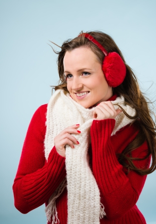 Beautiful young woman wearing a ear muffs and white scarf, vertical formatの写真素材