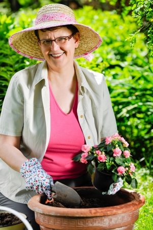 A mature woman planting flowers, sunny dayの写真素材