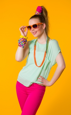 Happy girl with colorful clothes, yellow backgroundの写真素材