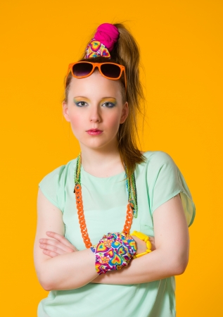 Severe girl with colorful clothes, yellow backgroundの写真素材