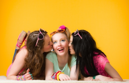 Three girls, girlfriends give a surprise kissの写真素材