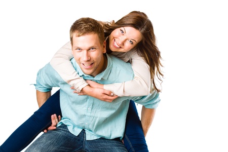Lovely attractive couple on piggyback, studio shot, white backgroundの写真素材