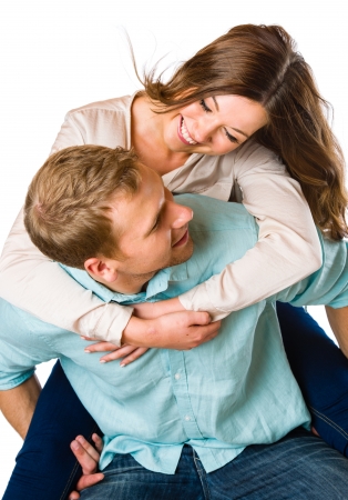 Lovely attractive couple on piggyback, studio shot, white backgroundの写真素材