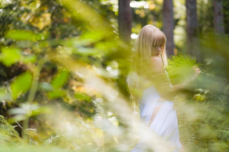 A fairy-like attractive woman wearing white garment. Behind the beautiful wilderness, horizon formatの写真素材