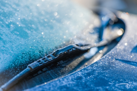 Frozen windshield, cold weather, sunlight on backlight, focus on foregroundの写真素材