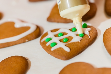 Decorating gingerbread cookie by sugar, parchment belowの写真素材