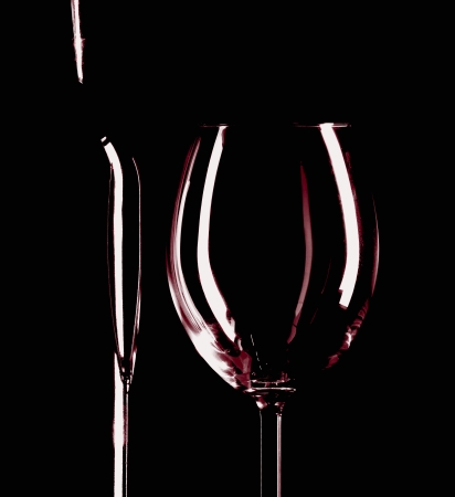 A wine bottle and wine glass side by side, black backgroundの写真素材
