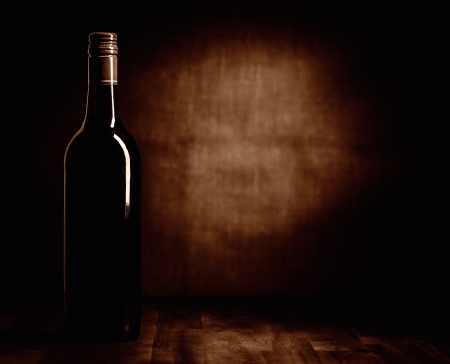 The red wine bottle on the table, dark brown theme and canvas backgroundの写真素材