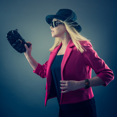 Urbane mature woman wearing a sunglasses and hat, studio shotの写真素材