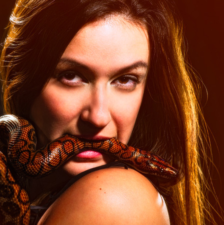 Beautiful woman and rainbow boa, dark background