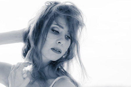 Close up portrait of young beautiful woman outdoor wind waving her hair, tinted black and white imageの写真素材