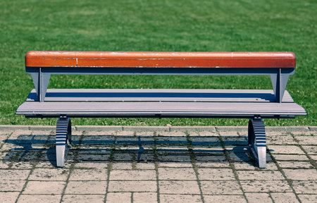 Empty metallic bench with a wooden seat back, cross processed image