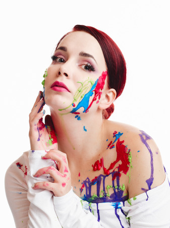 Beautiful young woman wearing white pullover and her face and body are painted, white backgroundの写真素材